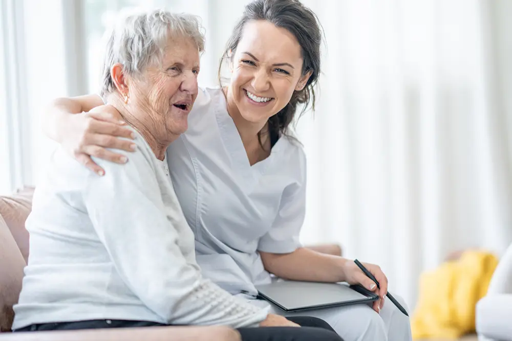 Carer supporting an older person after receiving an early bed or chair exit alert from the BedSense monitoring system.