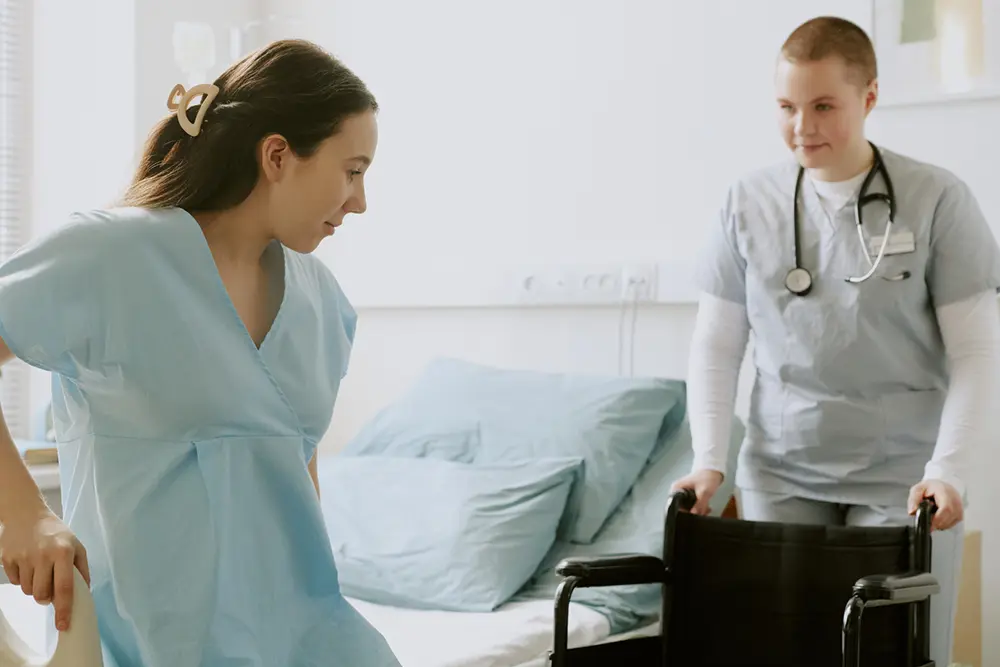 Care staff assisting a resident during a bed transfer, demonstrating how BedSense provides early alerts to support safer transfers and reduce fall risks.