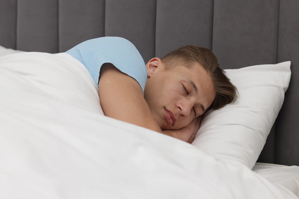 Person sleeping peacefully in bed supported by overnight monitoring with the Emfit Epilepsy Seizure Monitor
