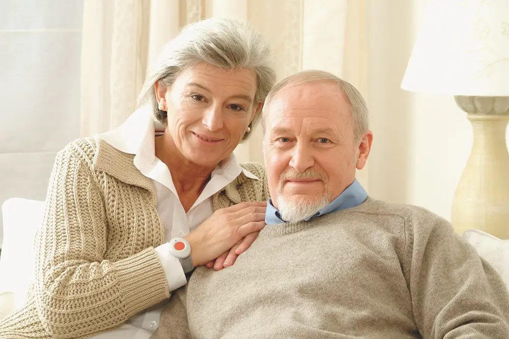 Older couple at home with a personal telecare alarm supporting rapid emergency response and independent living