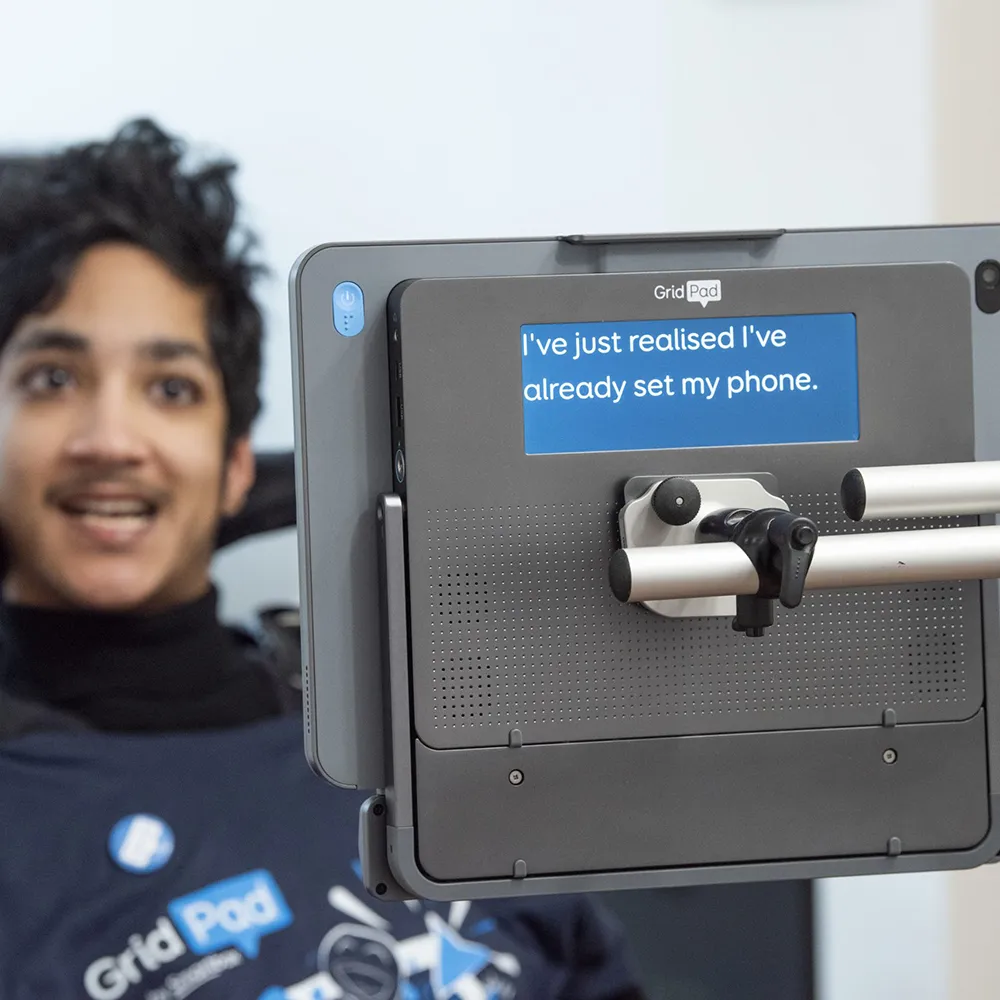 Grid Pad 13 with Eye Gaze Module in Use Grid Pad 13 mounted with Lumin-i eye gaze module being used by a young man