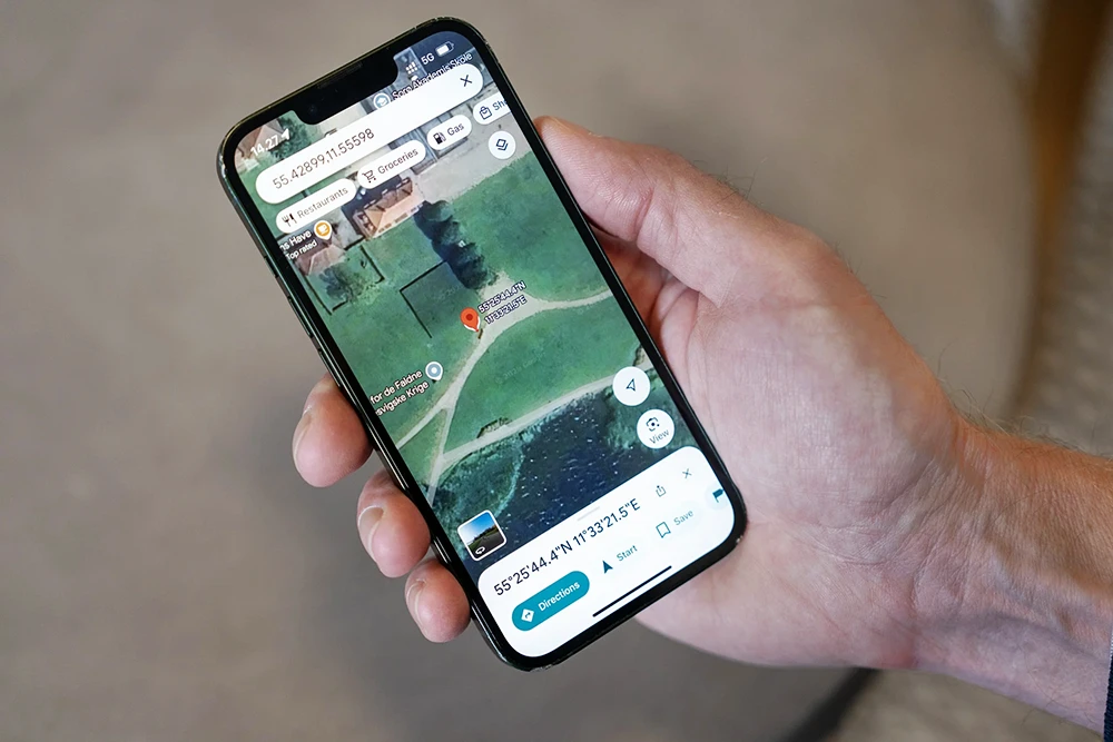Instant Mobile Alerts and GPS Monitoring App Hand holding a smartphone displaying a GPS location map and mobile monitoring app for instant alerts and emergency notifications