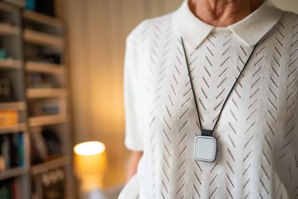 Person wearing a pendant personal alarm designed for intelligent alarm management