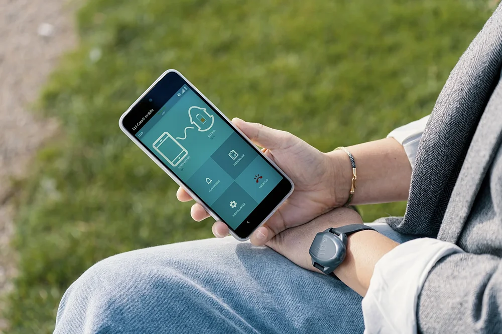 Mobile Telecare App for Freedom and Independence Person using a smartphone telecare app and wearable device outdoors to stay connected and independent while away from home