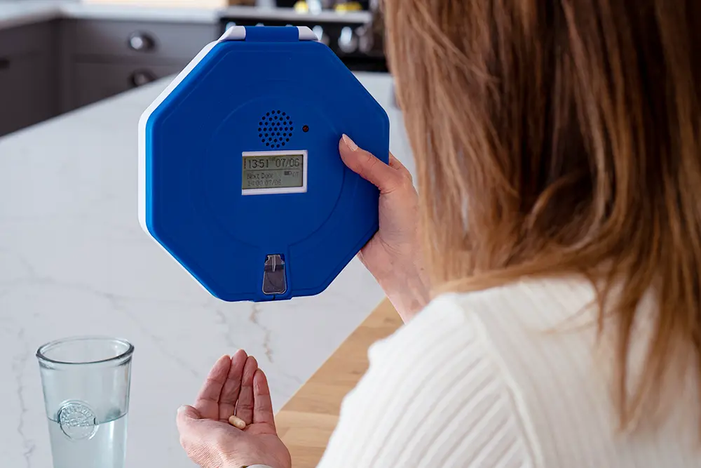 Person using an automatic medication dispenser with personalised audible and visual reminders