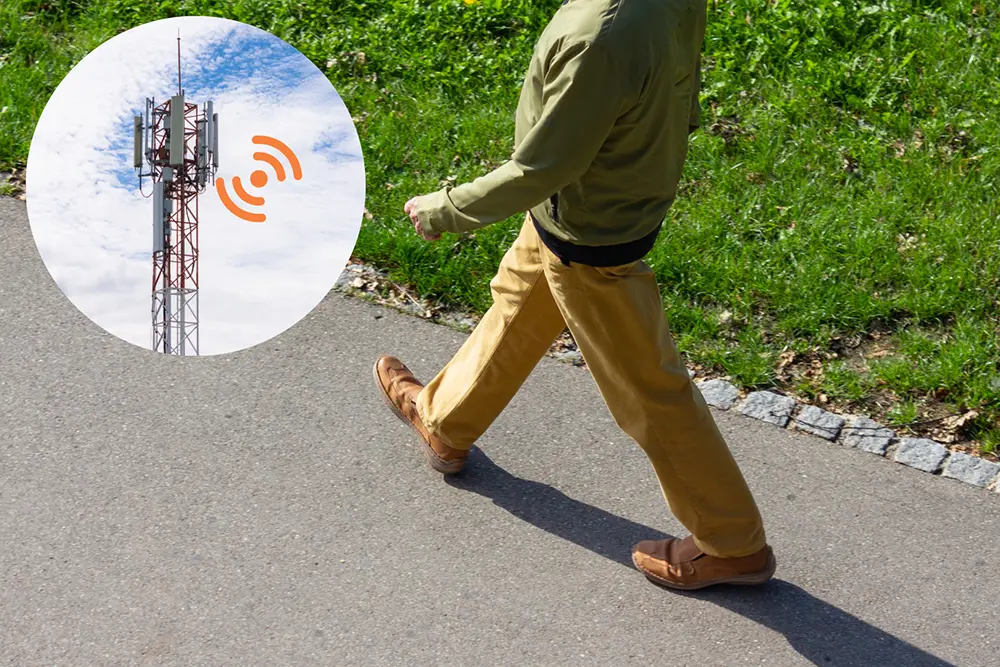 Person walking outdoors while the SafeSole GPS tracking insole connects to the strongest available mobile network using roaming SIM technology.
