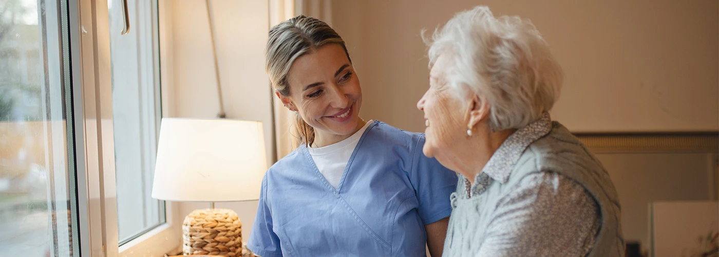 Supporting Independent Living and Reducing Wandering Risk Care professional supporting an elderly woman at home to help reduce dementia-related wandering risks