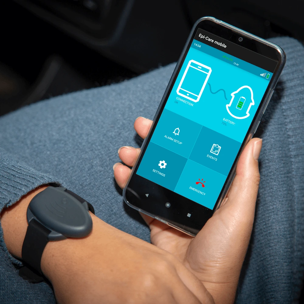 Epi-Care Mobile App for Seizure Alerts on the Move Smartphone displaying the Epi-Care Mobile app used for epilepsy seizure monitoring outdoors