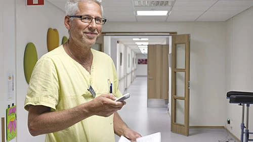 Faster Access to Assistance Healthcare professional using a nurse call device to respond quickly to resident needs