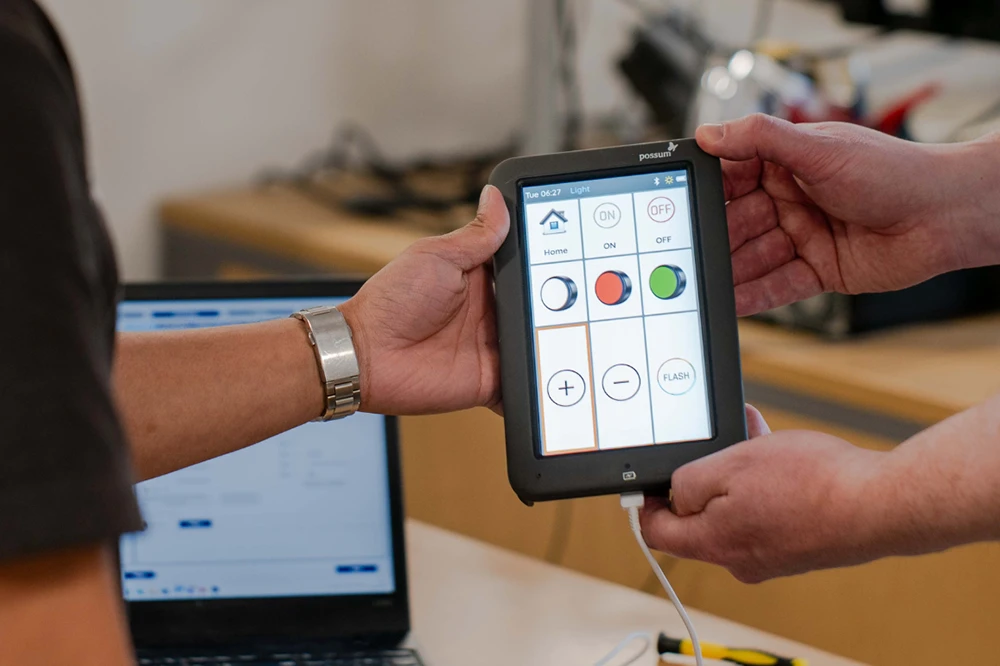 Possum engineer handing an environmental control device to a colleague during system maintenance and setup