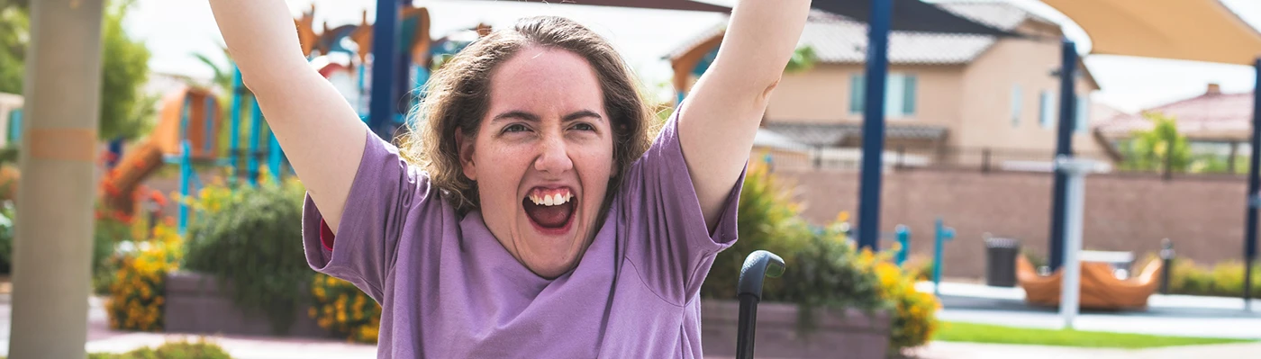 Wheelchair User Smiling wheelchair user celebrating outdoors