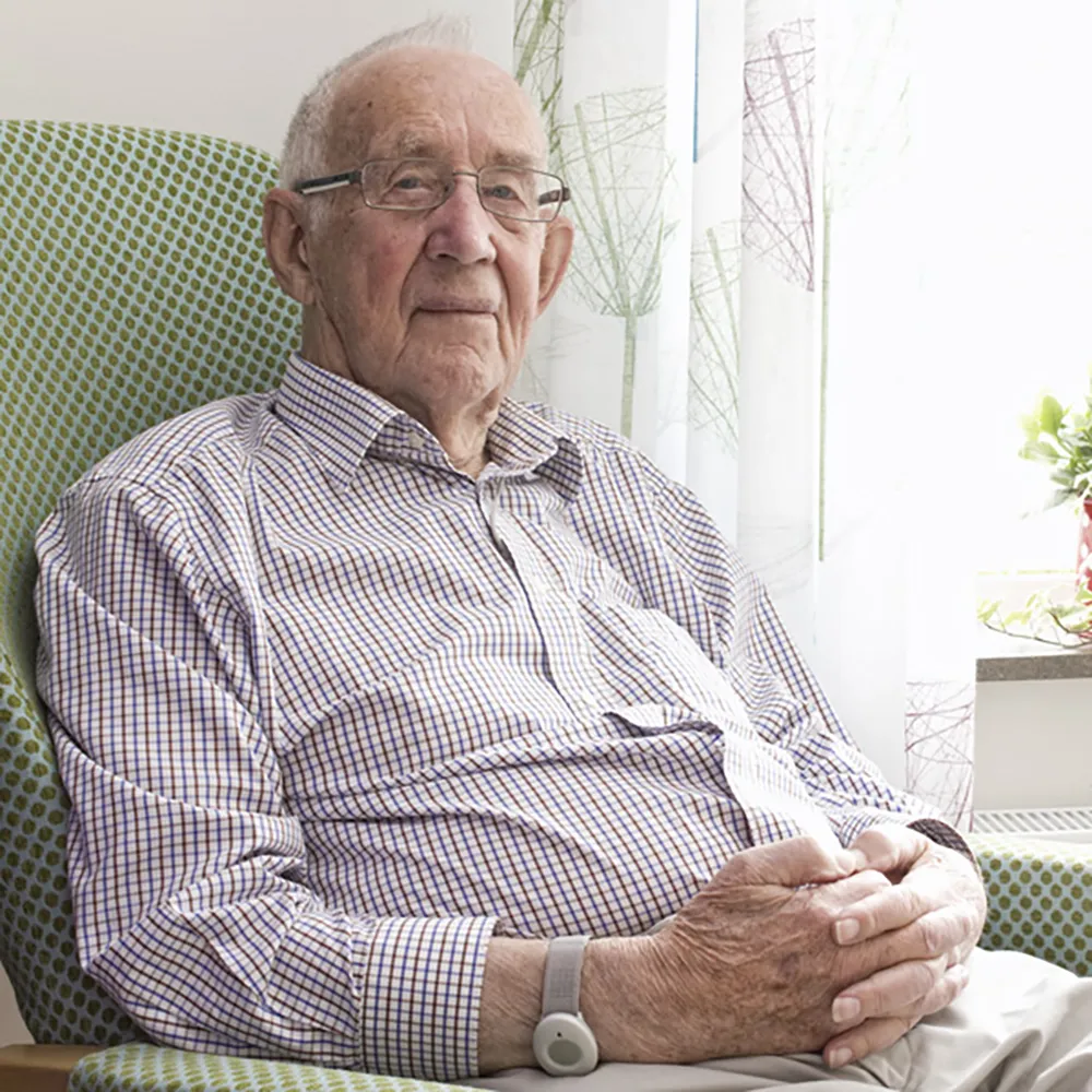 WanderSafe Wearable Device Older person wearing the WanderSafe wrist-worn location monitoring device in a care setting