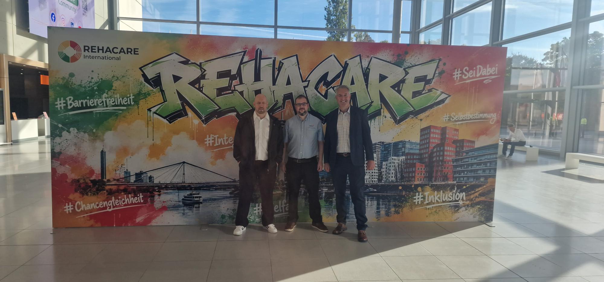 David, Mike and Jon stood in front of the Rehacare graffiti wall